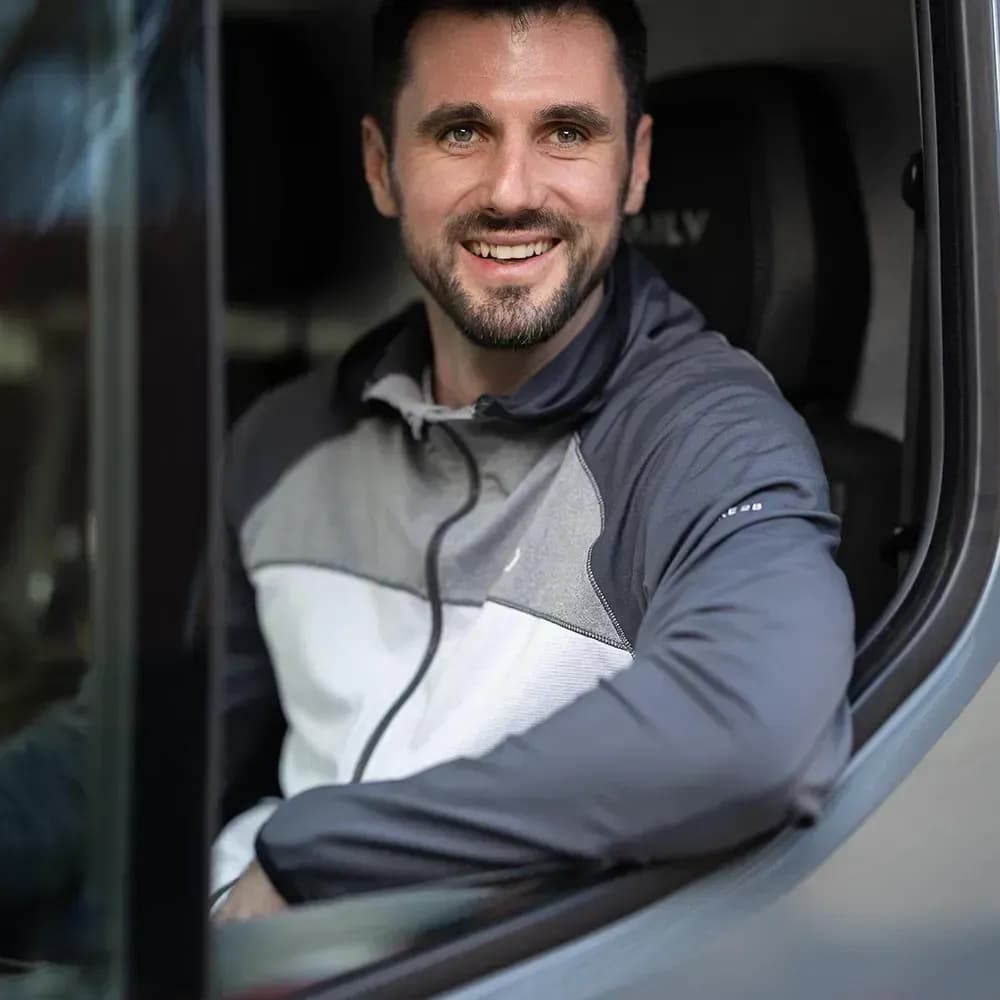 RP-Transport mit einem Lächeln im Führerhaus – Zuverlässigkeit und Freude am Beruf gehören hier zusammen.